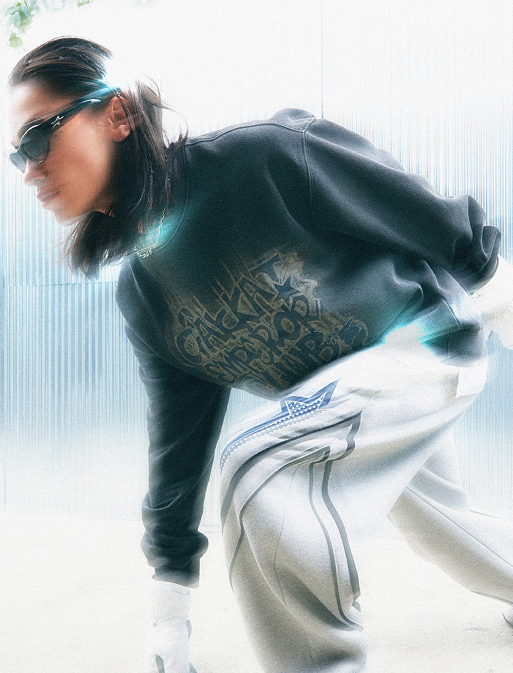 Person in running stance modeling sweats and sunglasses.
