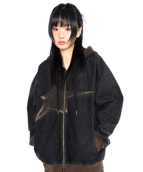 Girl wearing vintage wash zip up hoodie with star in center.