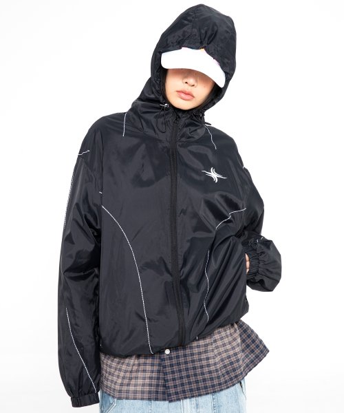 Girl wearing black windbreaker with white accents.